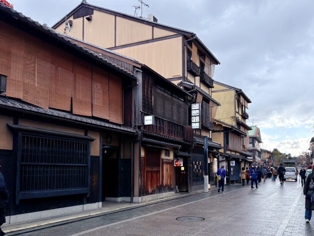 京都市の祇園地区にある歴史的な通りを人が行き交っています